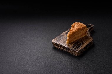 Koyu beton arka planda kremalı Napolyon pastası.