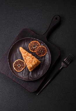 Koyu beton arka planda kremalı Napolyon pastası.