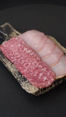 Lezzetli taze füme sosisler. Koyu beton arka planda dilimlerle kesilmiş.