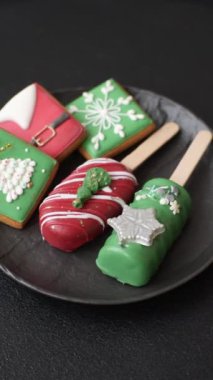 Çubuğun üzerinde noel ve yeni yılın stili ve renginde koyu beton bir zeminde çikolatayla kaplı doğal buzlu dondurma.
