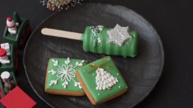 Çubuğun üzerinde noel ve yeni yılın stili ve renginde koyu beton bir zeminde çikolatayla kaplı doğal buzlu dondurma.