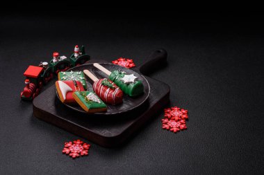 Çubuğun üzerinde noel ve yeni yılın stili ve renginde koyu beton bir zeminde çikolatayla kaplı doğal buzlu dondurma.