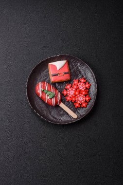 Çubuğun üzerinde noel ve yeni yılın stili ve renginde koyu beton bir zeminde çikolatayla kaplı doğal buzlu dondurma.