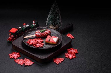 Çubuğun üzerinde noel ve yeni yılın stili ve renginde koyu beton bir zeminde çikolatayla kaplı doğal buzlu dondurma.