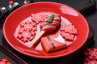 Çubuğun üzerinde noel ve yeni yılın stili ve renginde koyu beton bir zeminde çikolatayla kaplı doğal buzlu dondurma.