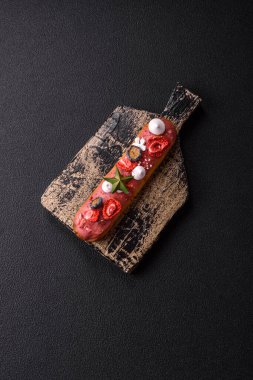 Noel ve Yeni Yıl için süslenmiş, kırmızı jöleli çikolata kaplı tatlı bir ekler.