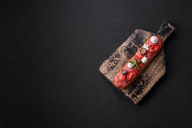 Noel ve Yeni Yıl için süslenmiş, kırmızı jöleli çikolata kaplı tatlı bir ekler.