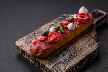 Noel ve Yeni Yıl için süslenmiş, kırmızı jöleli çikolata kaplı tatlı bir ekler.