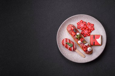 Noel ve Yeni Yıl için süslenmiş, kırmızı jöleli çikolata kaplı tatlı bir ekler.