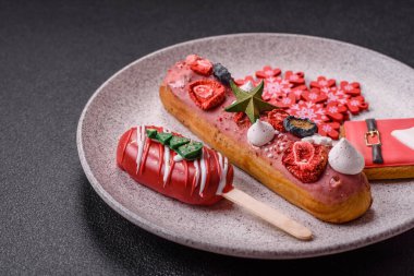 Noel ve Yeni Yıl için süslenmiş, kırmızı jöleli çikolata kaplı tatlı bir ekler.