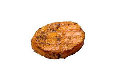 Dilimlenmiş balkabağı ve beyaz arka planda biberiye ve baharatla ızgara.