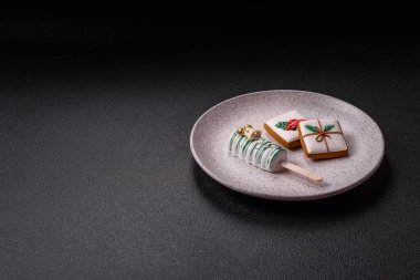 Çubuğun üzerinde noel ve yeni yılın stili ve renginde koyu beton bir zeminde çikolatayla kaplı doğal buzlu dondurma.