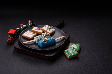 Çubuğun üzerinde noel ve yeni yılın stili ve renginde koyu beton bir zeminde çikolatayla kaplı doğal buzlu dondurma.