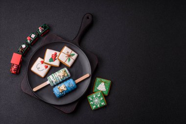 Çubuğun üzerinde noel ve yeni yılın stili ve renginde koyu beton bir zeminde çikolatayla kaplı doğal buzlu dondurma.