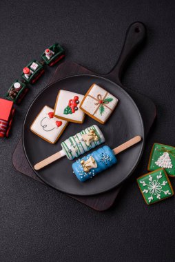 Çubuğun üzerinde noel ve yeni yılın stili ve renginde koyu beton bir zeminde çikolatayla kaplı doğal buzlu dondurma.