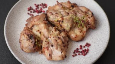 Koyu beton bir arka planda tuzlu, baharatlı ve otlu ızgara kemiksiz tavuk budu.