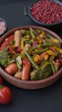Sebze karışımı mısır, havuç, biber, brokoli, teriyaki soslu soğan koyu beton arka planda seramik bir tabakta
