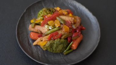 Sebze karışımı mısır, havuç, biber, brokoli, teriyaki soslu soğan koyu beton arka planda seramik bir tabakta