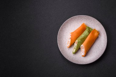 Krep krem peynirle yuvarlandı. Tatlı veya ekşi, koyu beton arka planda.