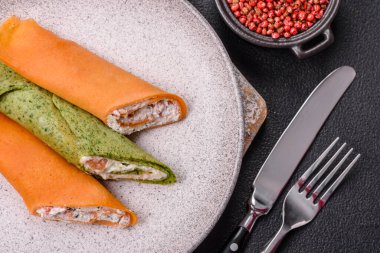 Krep krem peynirle yuvarlandı. Tatlı veya ekşi, koyu beton arka planda.