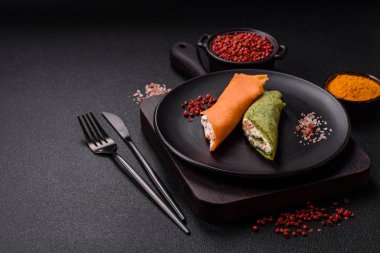 Krep krem peynirle yuvarlandı. Tatlı veya ekşi, koyu beton arka planda.