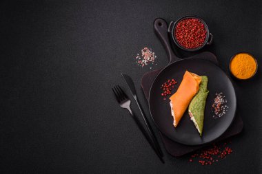 Krep krem peynirle yuvarlandı. Tatlı veya ekşi, koyu beton arka planda.