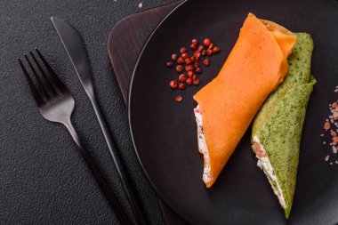 Krep krem peynirle yuvarlandı. Tatlı veya ekşi, koyu beton arka planda.