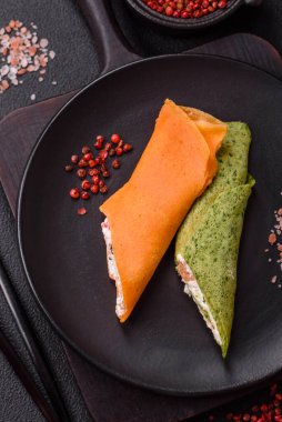 Krep krem peynirle yuvarlandı. Tatlı veya ekşi, koyu beton arka planda.