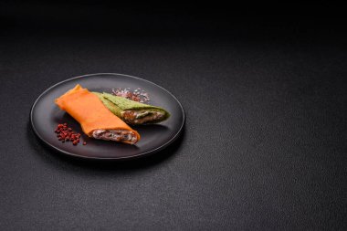 Krep krem peynirle yuvarlandı. Tatlı veya ekşi, koyu beton arka planda.