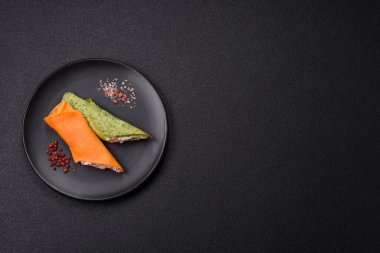 Krep krem peynirle yuvarlandı. Tatlı veya ekşi, koyu beton arka planda.