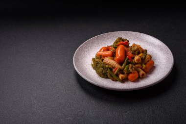 Sebze karışımı mısır, havuç, biber, brokoli, teriyaki soslu soğan koyu beton arka planda seramik bir tabakta