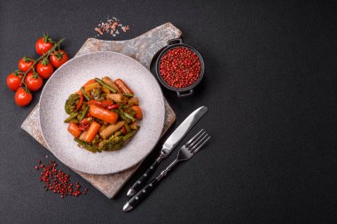 Sebze karışımı mısır, havuç, biber, brokoli, teriyaki soslu soğan koyu beton arka planda seramik bir tabakta