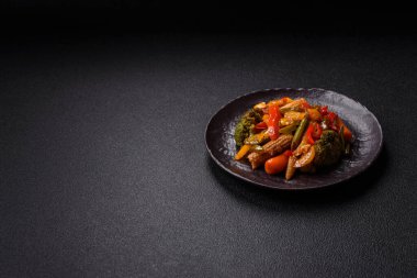 Sebze karışımı mısır, havuç, biber, brokoli, teriyaki soslu soğan koyu beton arka planda seramik bir tabakta