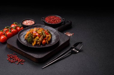 Sebze karışımı mısır, havuç, biber, brokoli, teriyaki soslu soğan koyu beton arka planda seramik bir tabakta