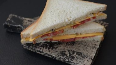 Jambonlu, salamlı, domatesli, hardallı, tuzlu ve baharatlı sandviç.