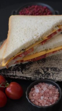 Jambonlu, salamlı, domatesli, hardallı, tuzlu ve baharatlı sandviç.