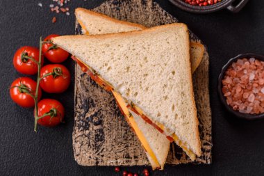 Jambonlu, salamlı, domatesli, hardallı, tuzlu ve baharatlı sandviç.