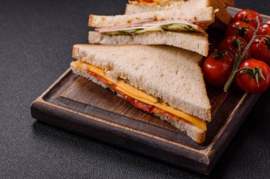 Jambonlu, salamlı, domatesli, hardallı, tuzlu ve baharatlı sandviç.