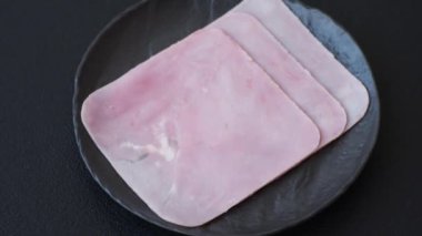 Jambon, sağlıklı bir kahvaltı için lezzetli sandviçler yapmak için dilimlere bölünmüş.