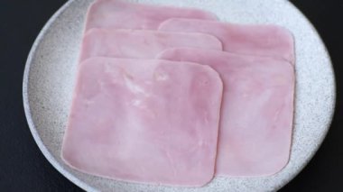 Jambon, sağlıklı bir kahvaltı için lezzetli sandviçler yapmak için dilimlere bölünmüş.