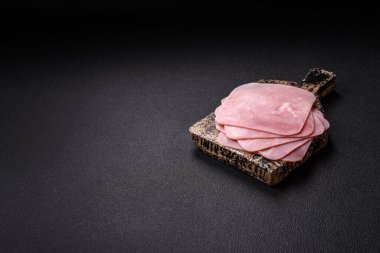 Jambon, sağlıklı bir kahvaltı için lezzetli sandviçler yapmak için dilimlere bölünmüş.