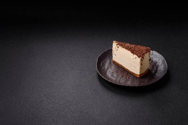 Koyu beton arka planda doğranmış çikolata serpiştirilmiş tatlı cheesecake.