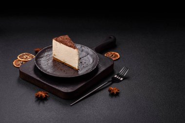 Koyu beton arka planda doğranmış çikolata serpiştirilmiş tatlı cheesecake.