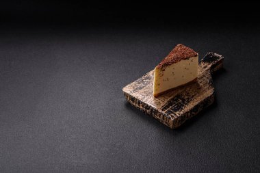 Koyu beton arka planda doğranmış çikolata serpiştirilmiş tatlı cheesecake.