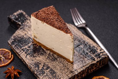 Koyu beton arka planda doğranmış çikolata serpiştirilmiş tatlı cheesecake.