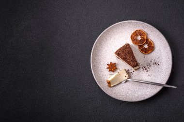 Koyu beton arka planda doğranmış çikolata serpiştirilmiş tatlı cheesecake.