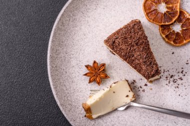 Koyu beton arka planda doğranmış çikolata serpiştirilmiş tatlı cheesecake.