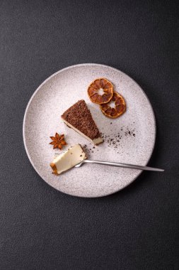 Koyu beton arka planda doğranmış çikolata serpiştirilmiş tatlı cheesecake.