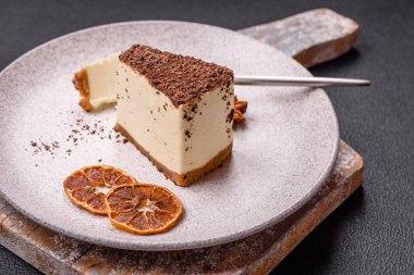 Koyu beton arka planda doğranmış çikolata serpiştirilmiş tatlı cheesecake.