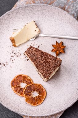 Koyu beton arka planda doğranmış çikolata serpiştirilmiş tatlı cheesecake.